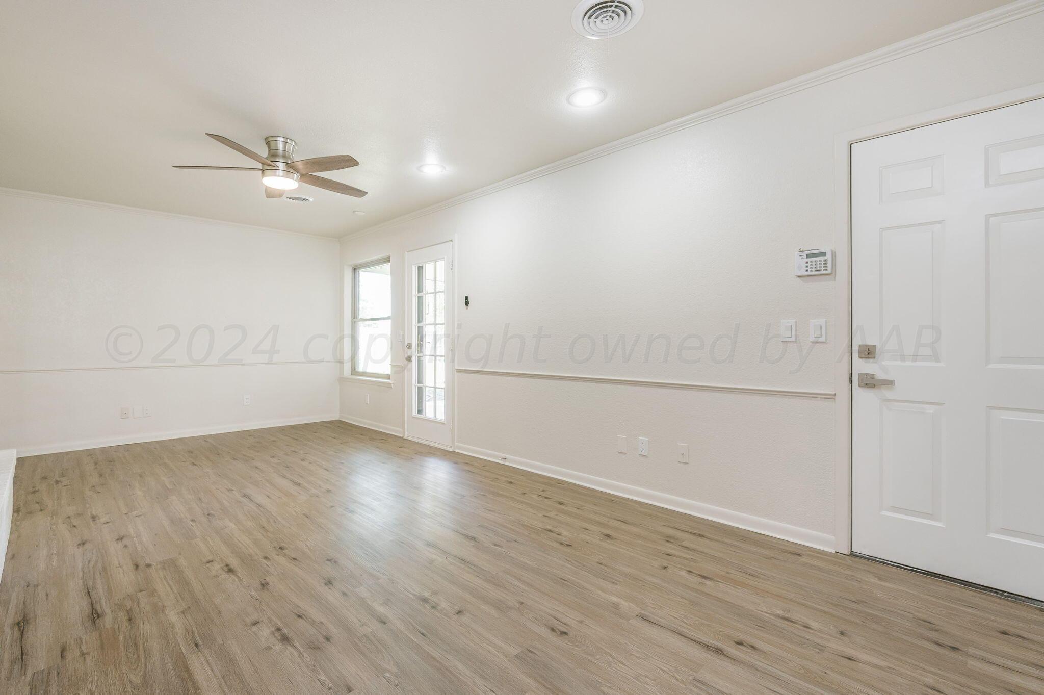 7220 Montague Drive Amarillo, TX 79109 - Photo 11 of 29 an empty room with wooden floor ceiling fan and windows