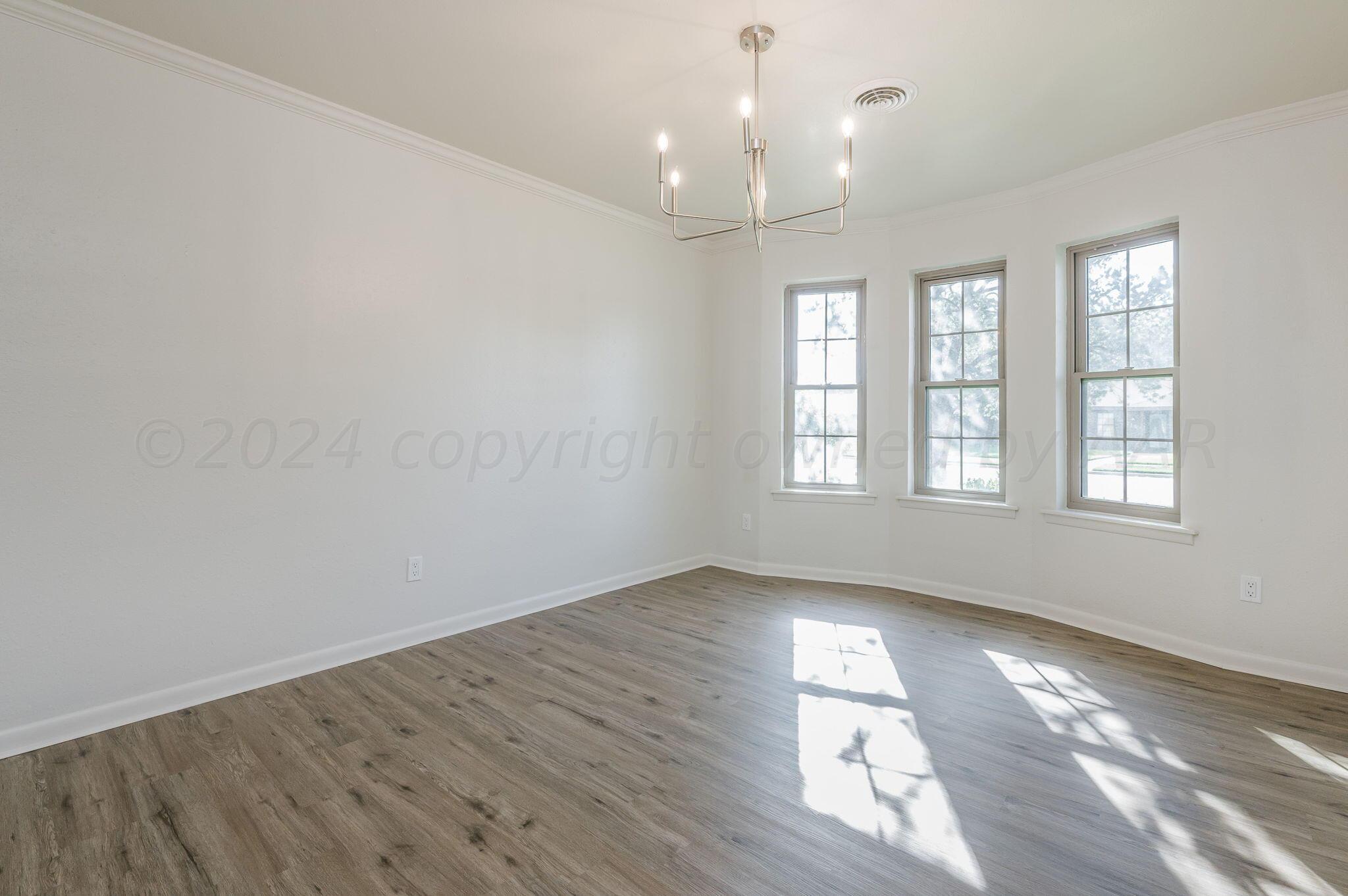 7220 Montague Drive Amarillo, TX 79109 - Photo 12 of 29 an empty room with wooden floor and windows