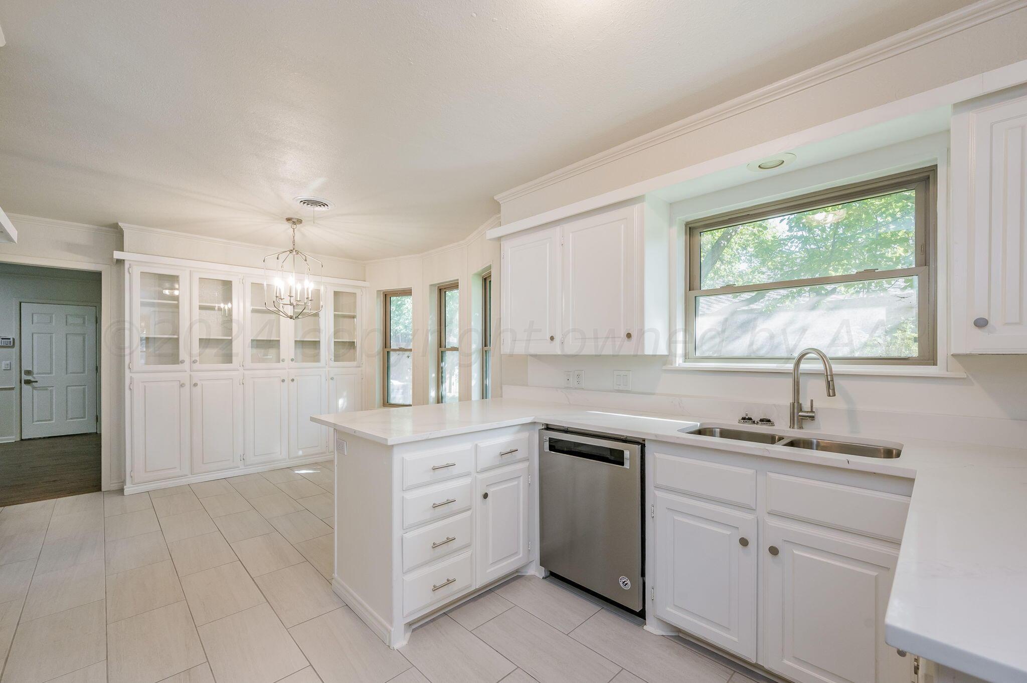 7220 Montague Drive Amarillo, TX 79109 - Photo 3 of 29 a kitchen with a sink window and cabinets