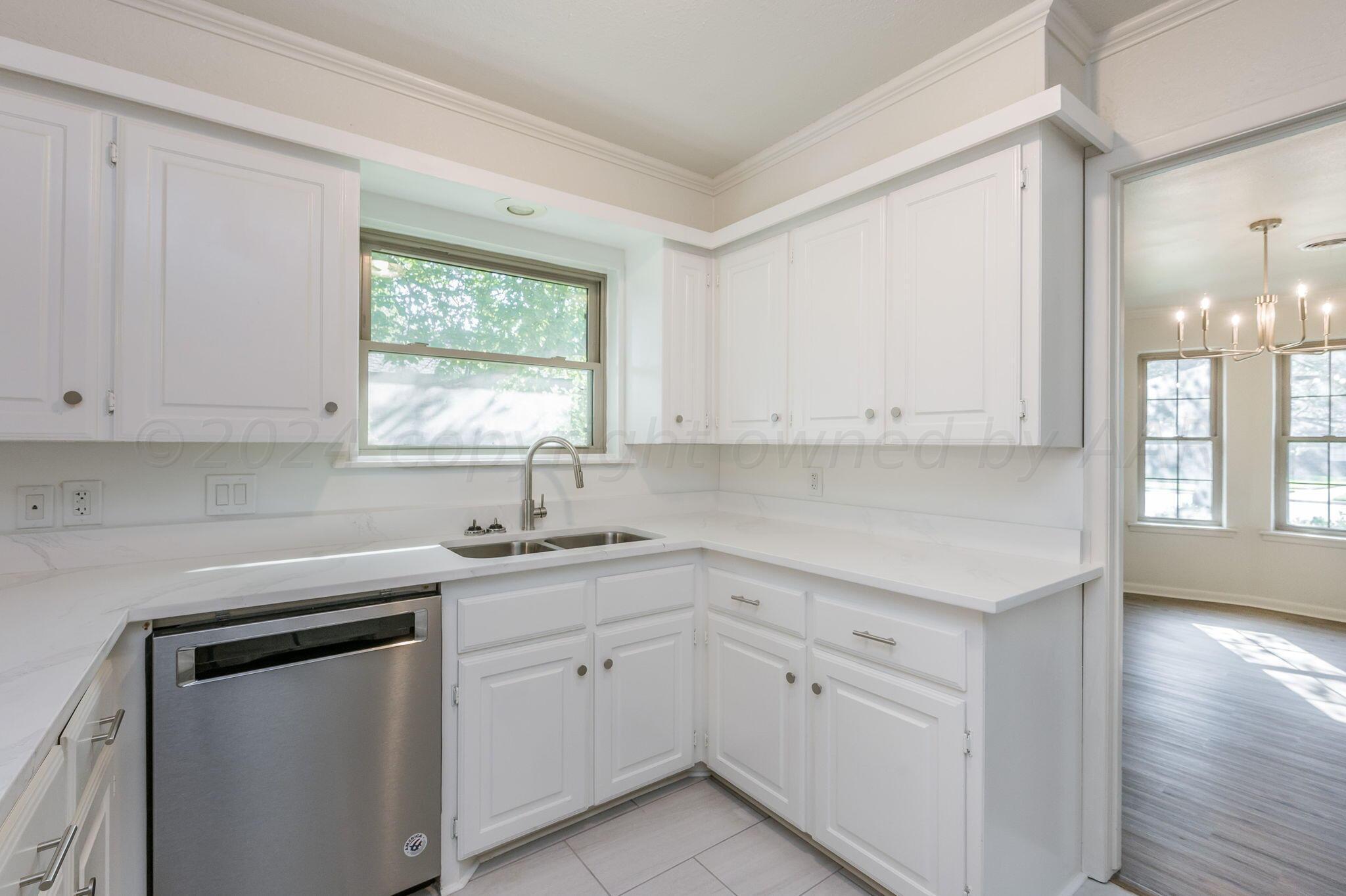 7220 Montague Drive Amarillo, TX 79109 - Photo 5 of 29 a kitchen with white cabinets appliances a sink and a window