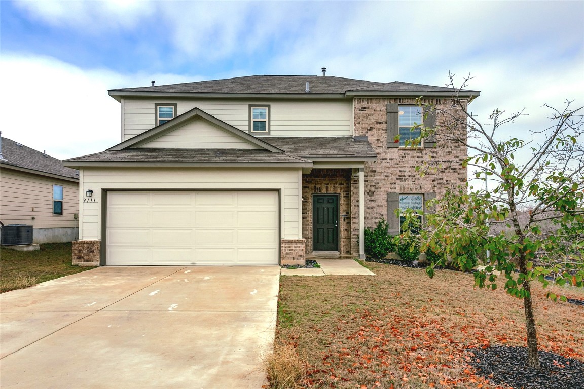 a front view of a house with a yard and garage