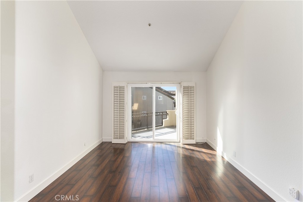 430 Lake Street, Unit 304 Huntington Beach, CA 92648 - Photo 27 of 46 an empty room with wooden floor and windows