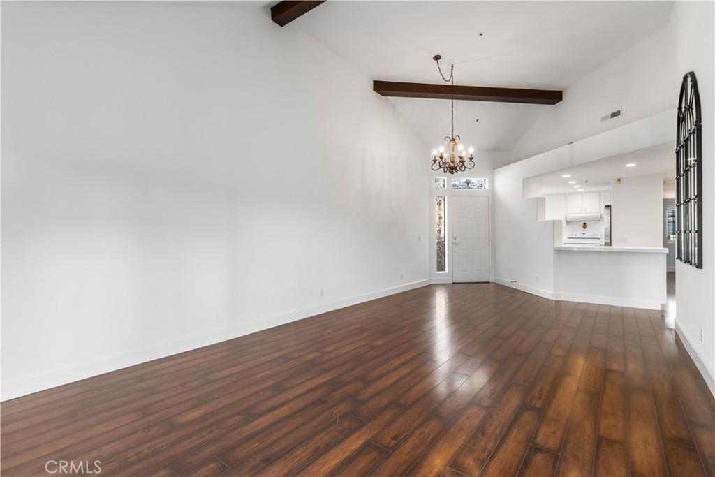 430 Lake Street, Unit 304 Huntington Beach, CA 92648 - Photo 9 of 46 a view of a room with wooden floor a ceiling fan and kitchen view