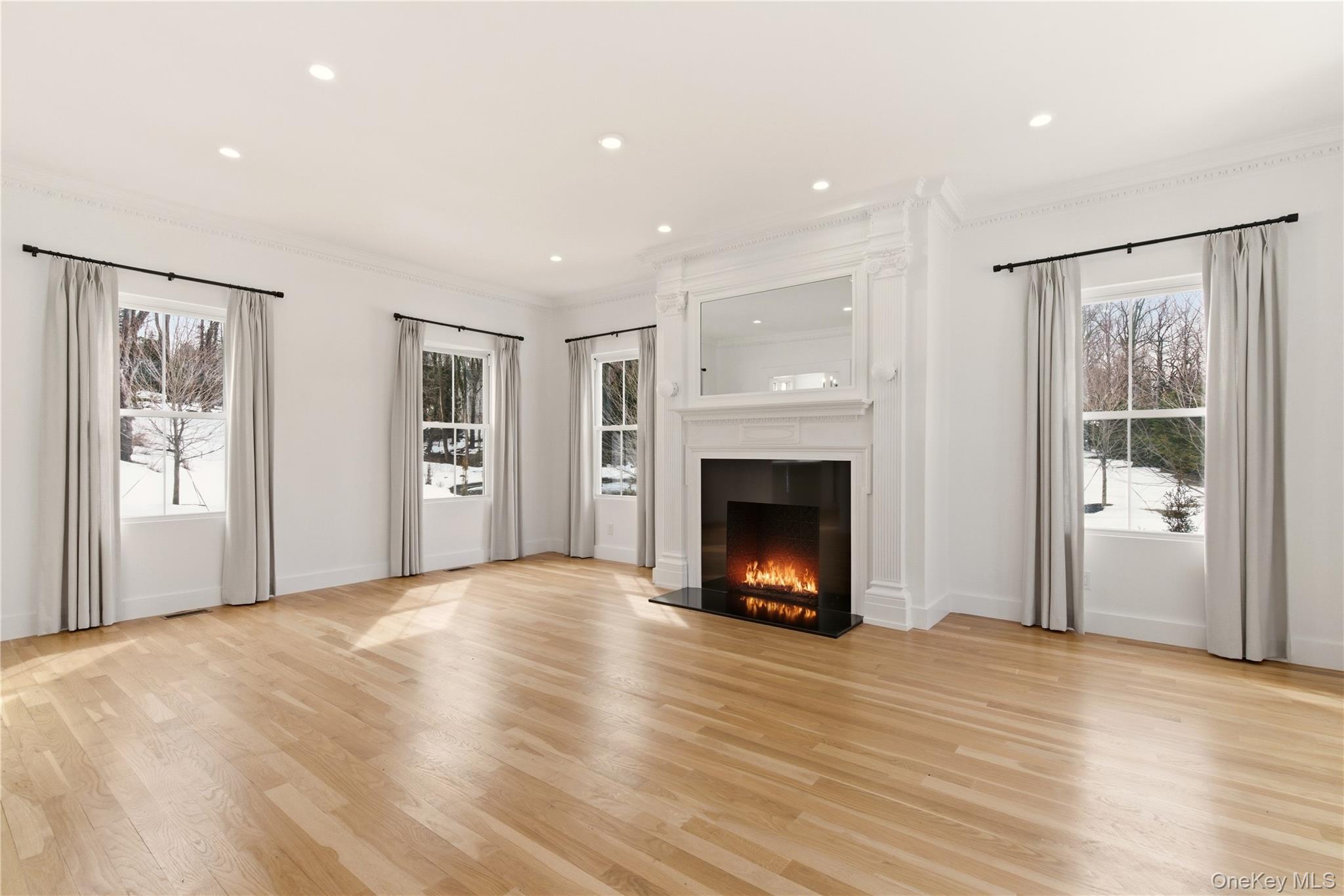 77 Cove Road Oyster Bay, NY 11771 - Photo 16 of 45 a view of empty room with a fireplace and wooden floor