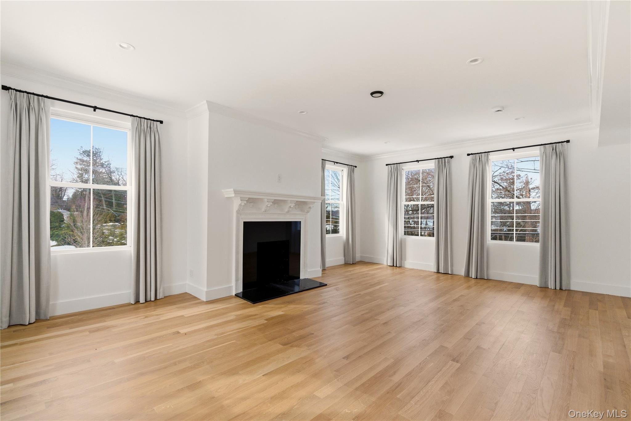 77 Cove Road Oyster Bay, NY 11771 - Photo 19 of 45 a view of an empty room with a window and fireplace