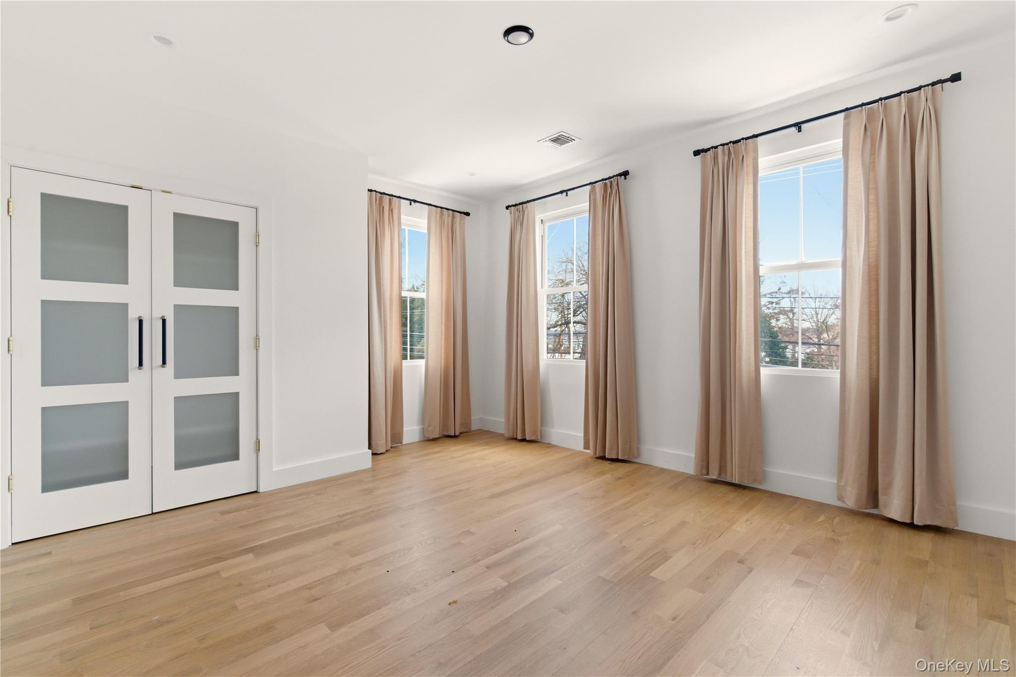 77 Cove Road Oyster Bay, NY 11771 - Photo 26 of 45 a view of an empty room with wooden floor and a window