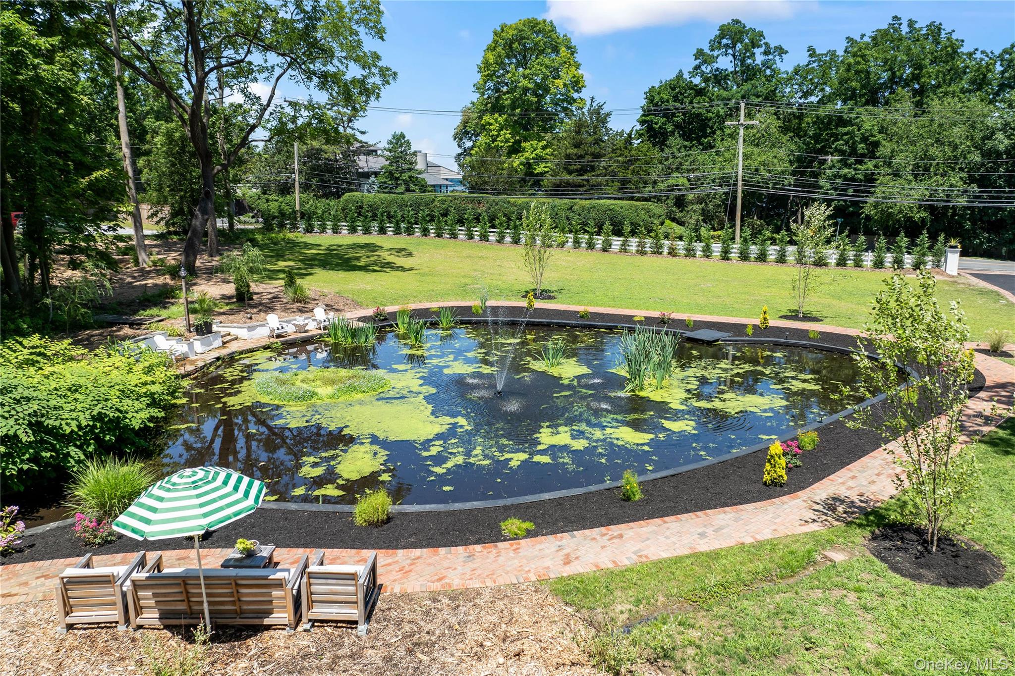 77 Cove Road Oyster Bay, NY 11771 - Photo 30 of 45 a view of a swimming pool with lawn chairs under an umbrella