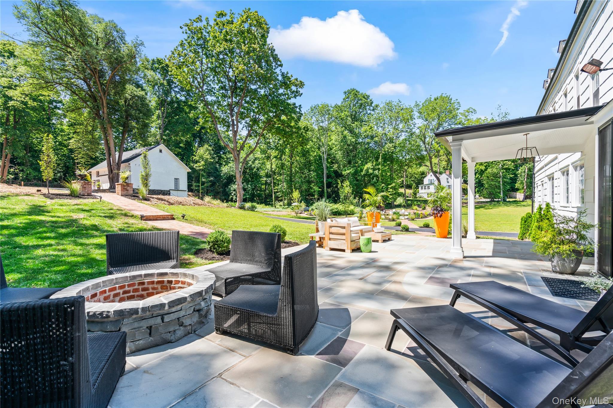 77 Cove Road Oyster Bay, NY 11771 - Photo 35 of 45 a view of a patio with a dining table and chairs with a couches near a yard