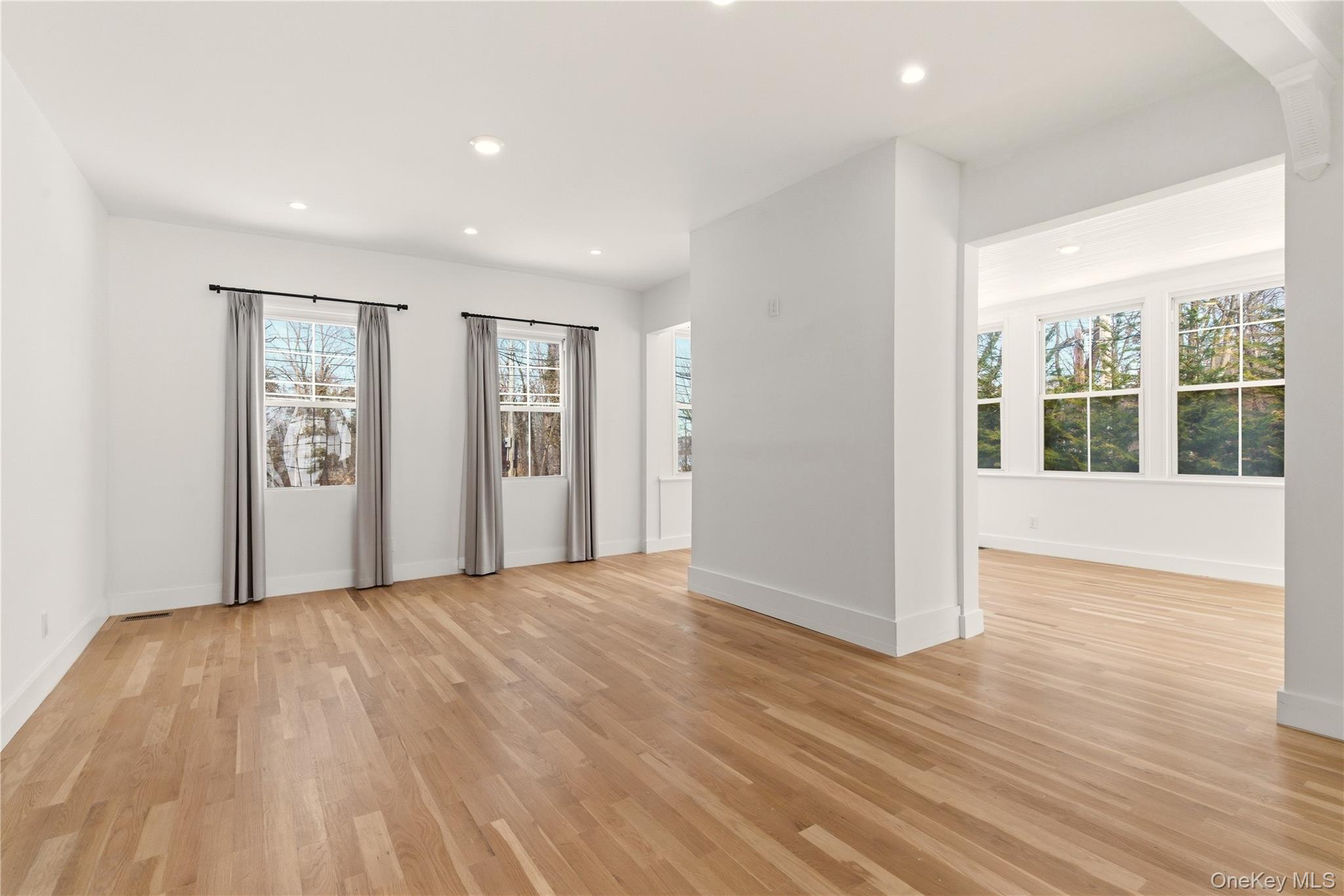 77 Cove Road Oyster Bay, NY 11771 - Photo 9 of 45 a view of an empty room with wooden floor and windows