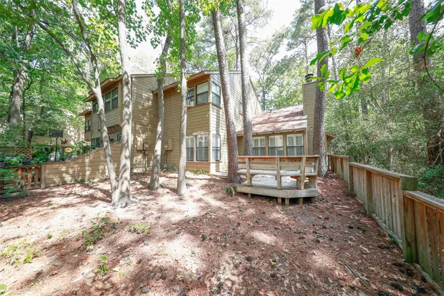 an empty room with a chandelier fan and windows