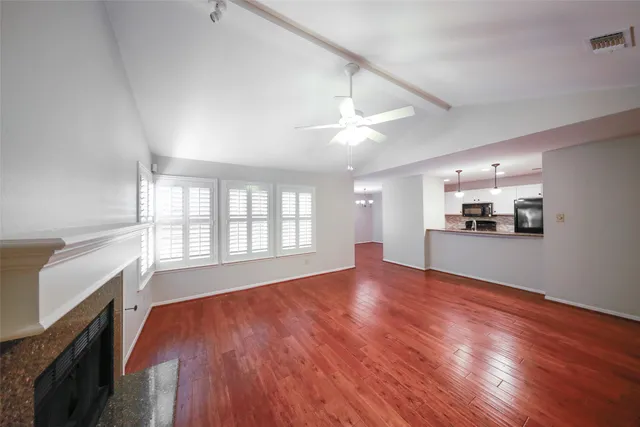 an empty room with wooden floor and fireplace