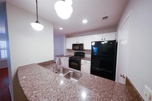 a kitchen with stainless steel appliances kitchen island a stove and a wooden floor