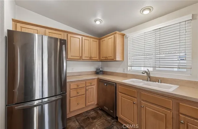 a kitchen with a refrigerator sink and cabinets