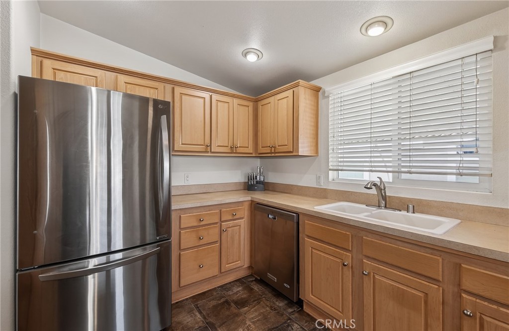 12367 4th Street, Unit 71 Yucaipa, CA 92399 - Photo 12 of 25 a kitchen with a refrigerator sink and cabinets
