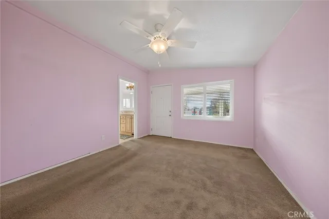 an empty room with windows and ceiling fan