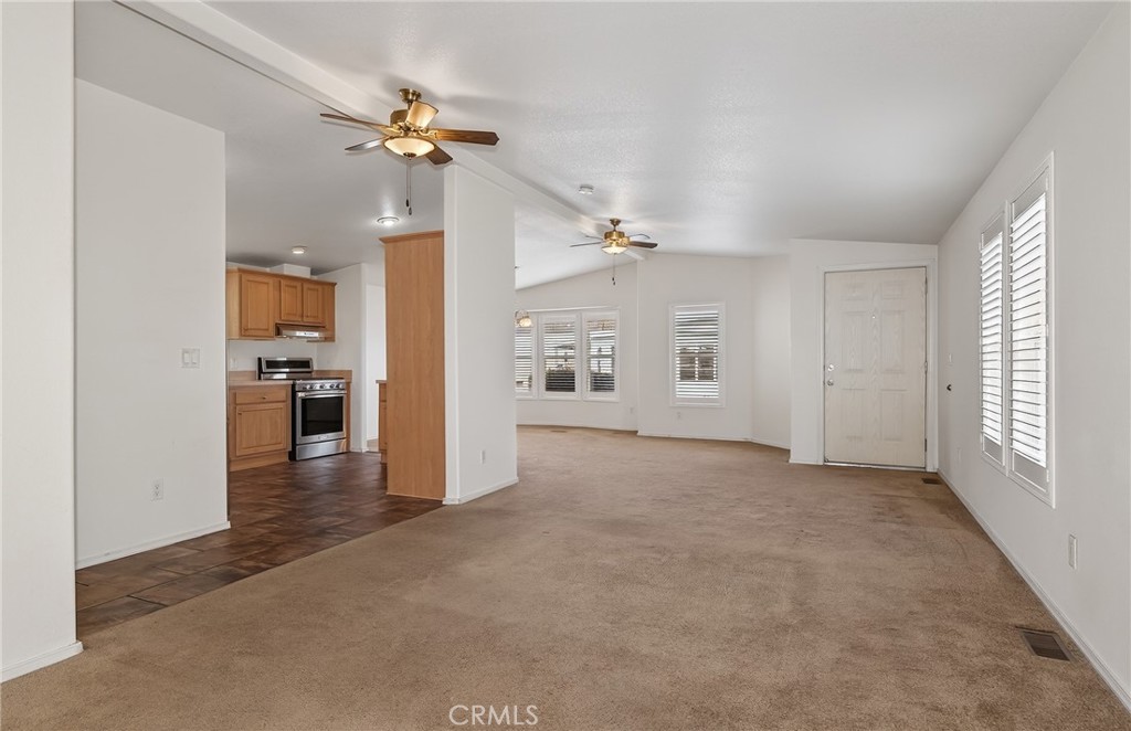 12367 4th Street, Unit 71 Yucaipa, CA 92399 - Photo 7 of 25 an empty room with chandelier fan and windows
