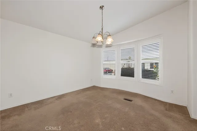 a view of a livingroom with a chandelier fan and window