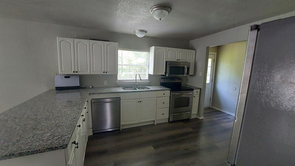 1107 Beech Street Bonham, TX 75418 - Photo 13 of 14 a kitchen with a sink stove and microwave