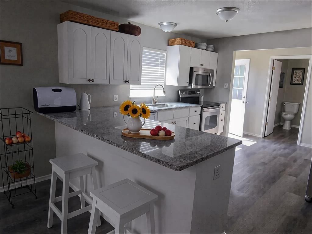 1107 Beech Street Bonham, TX 75418 - Photo 5 of 14 a kitchen with a table chairs and a refrigerator