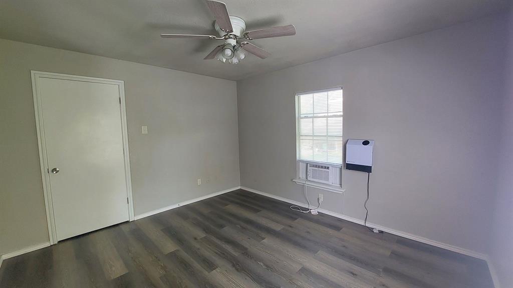 1107 Beech Street Bonham, TX 75418 - Photo 8 of 14 an empty room with wooden floor fan and windows