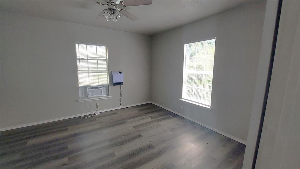 1107 Beech Street Bonham, TX 75418 - Photo 9 of 14 a view of an empty room with a window and wooden floor