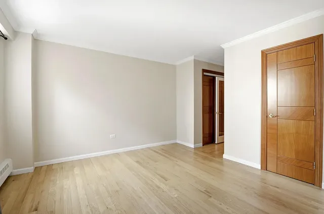 an empty room with wooden floor and closet