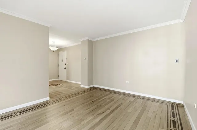 a view of an empty room with wooden floor