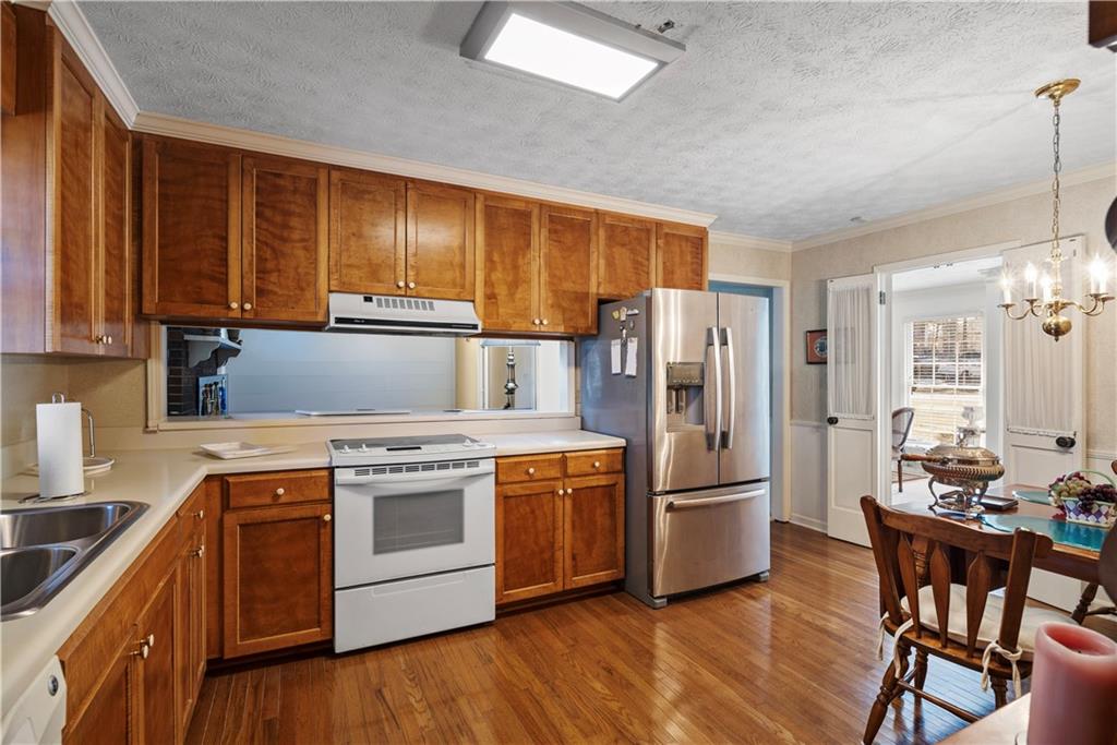 112 Thornwood Drive Southwest Rome, GA 30165 - Photo 13 of 30 a kitchen with stainless steel appliances granite countertop a refrigerator a stove a sink dishwasher and a dining table with wooden floor