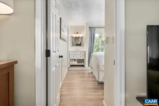a view of a bedroom with wooden floor and hallway