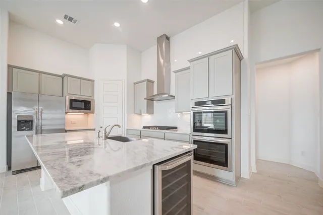 a kitchen with stainless steel appliances kitchen island granite countertop a stove a sink and a microwave