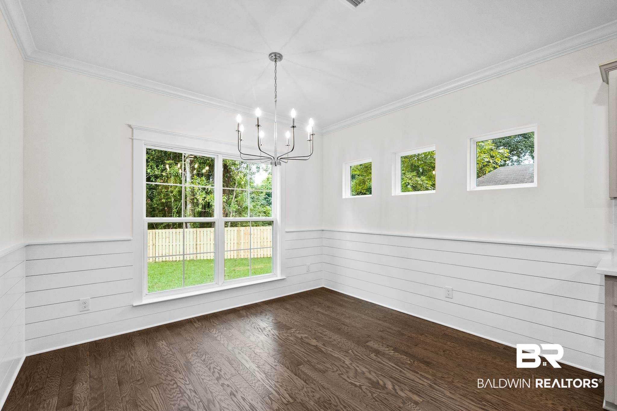 29 Signal Hill Road Daphne, AL 36527 - Photo 8 of 36 Unfurnished dining area with dark wood-type flooring, wood walls, a chandelier, and ornamental molding