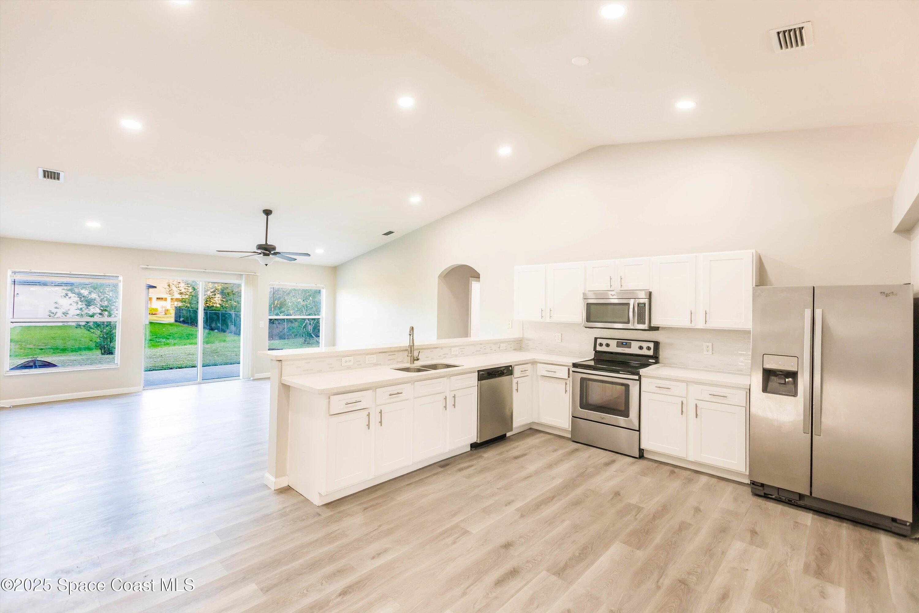 3061 Tazewell Avenue Southeast Palm Bay, FL 32909 - Photo 13 of 30 a kitchen with a stove a sink and a refrigerator