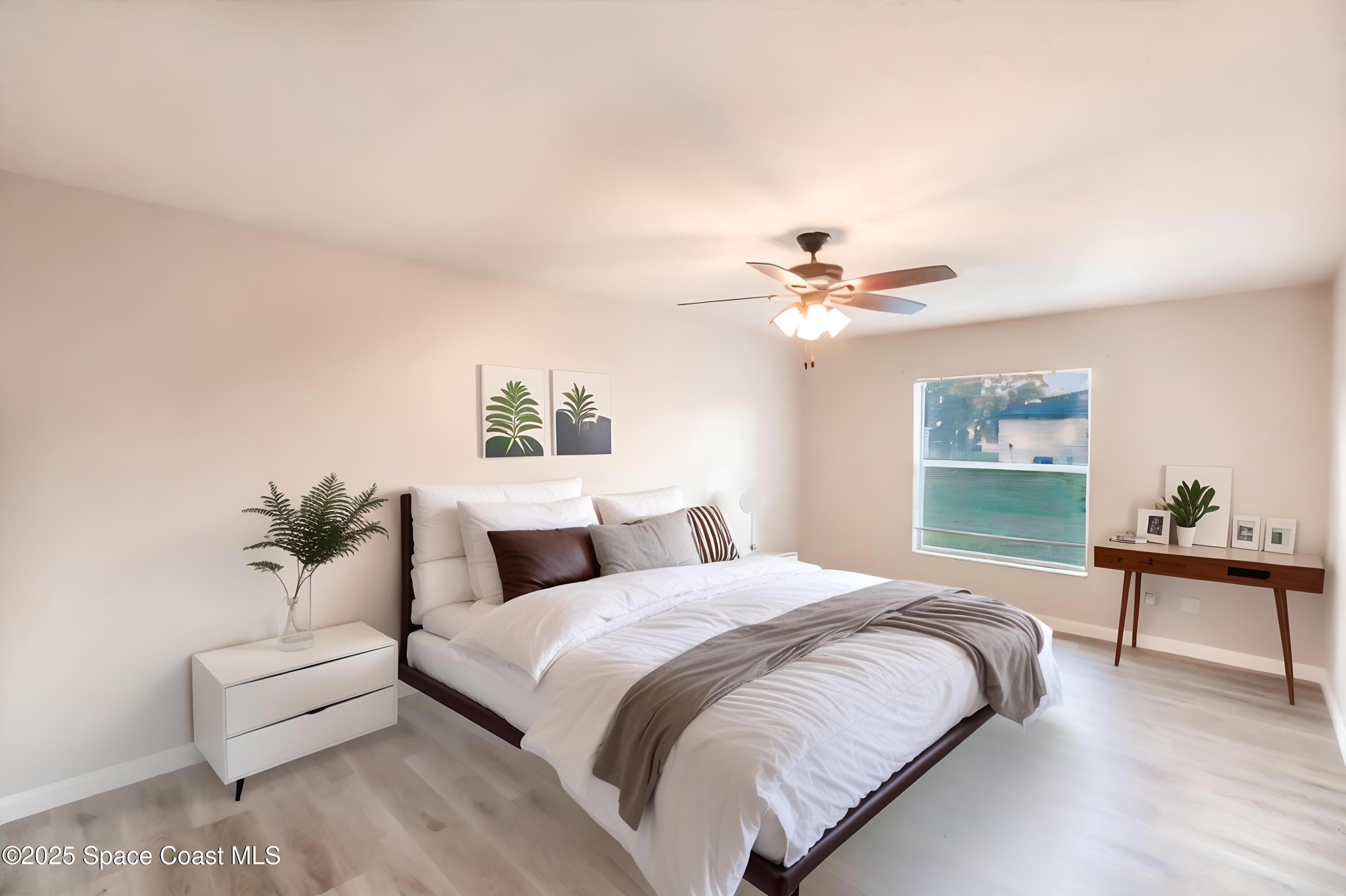 3061 Tazewell Avenue Southeast Palm Bay, FL 32909 - Photo 15 of 30 a bedroom with a large bed and a chandelier