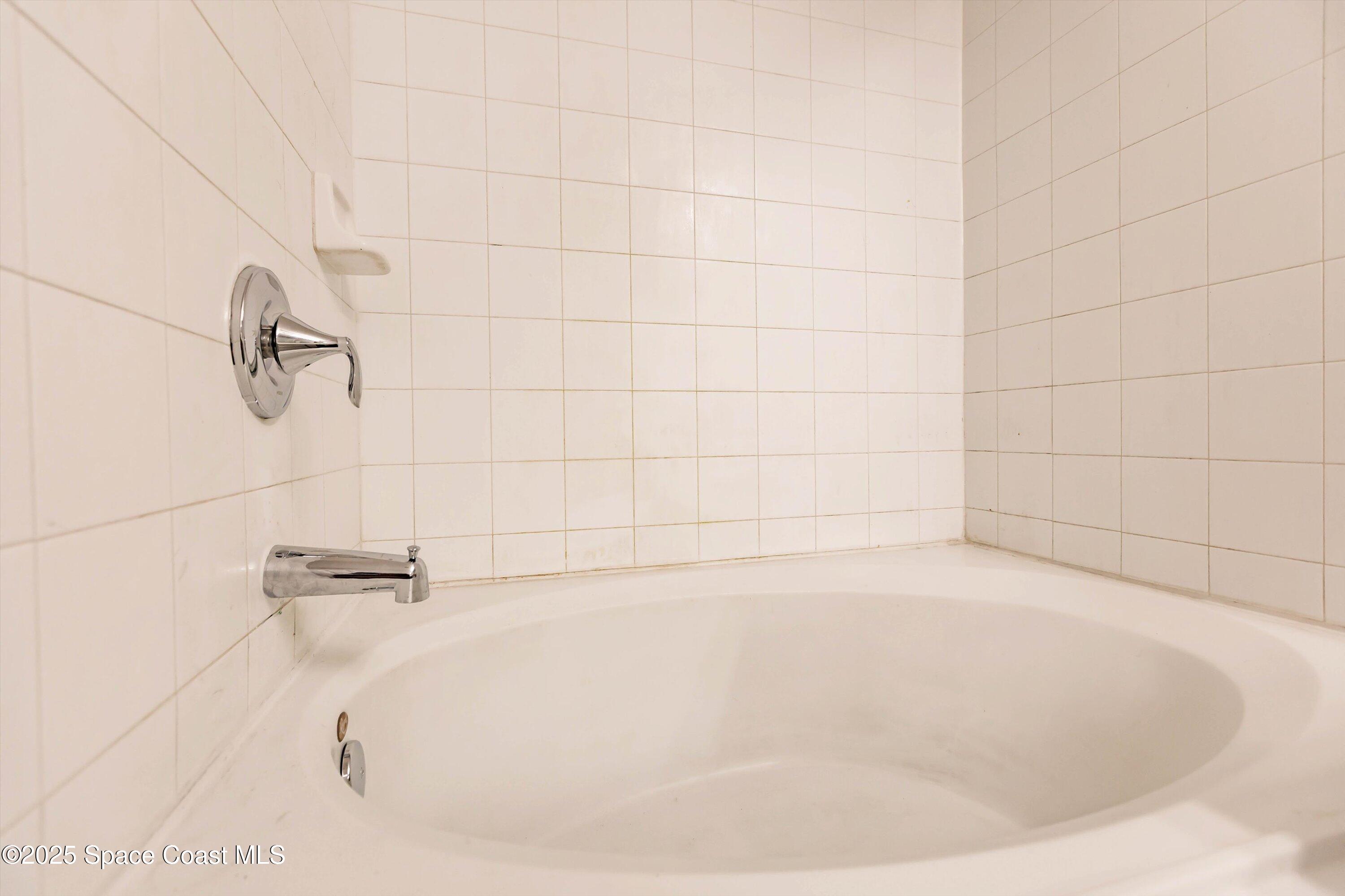 3061 Tazewell Avenue Southeast Palm Bay, FL 32909 - Photo 18 of 30 a white bath tub sitting in a bathroom