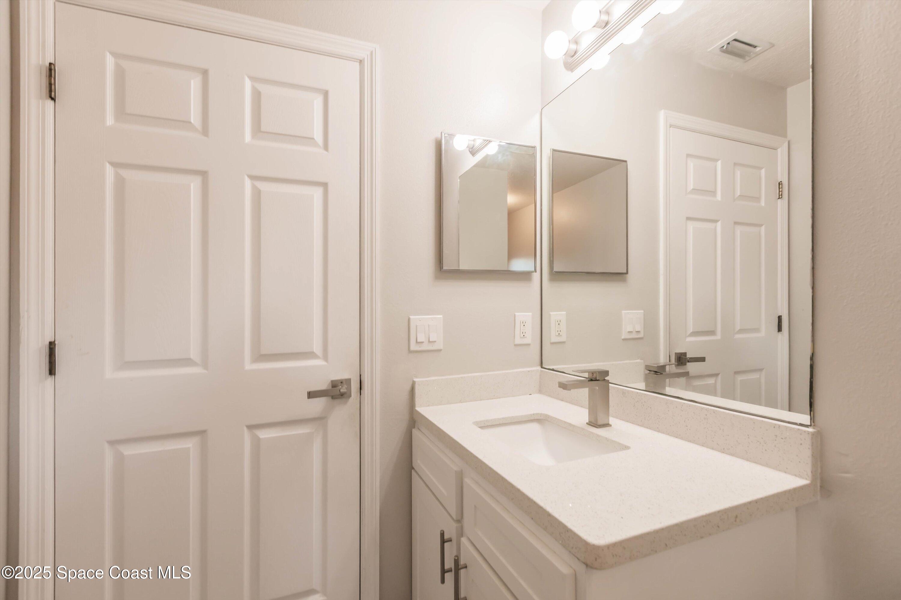 3061 Tazewell Avenue Southeast Palm Bay, FL 32909 - Photo 24 of 30 a bathroom with a sink vanity and a mirror