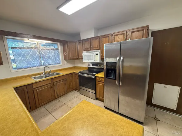 a kitchen with granite countertop a refrigerator and a sink