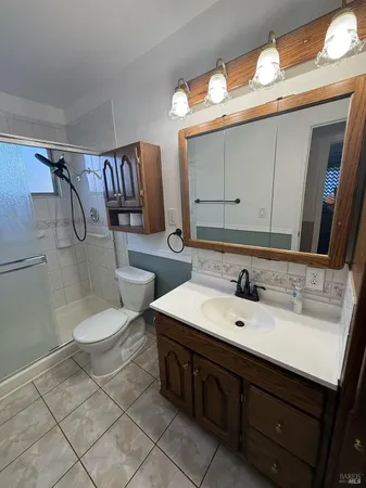 a bathroom with a double vanity sink mirror and toilet
