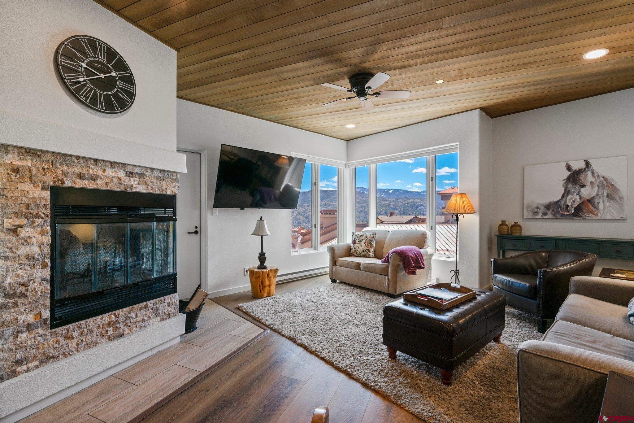 a living room with furniture a flat screen tv and a fireplace