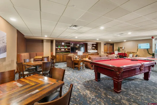 a living room with furniture a table tennis table and a rug
