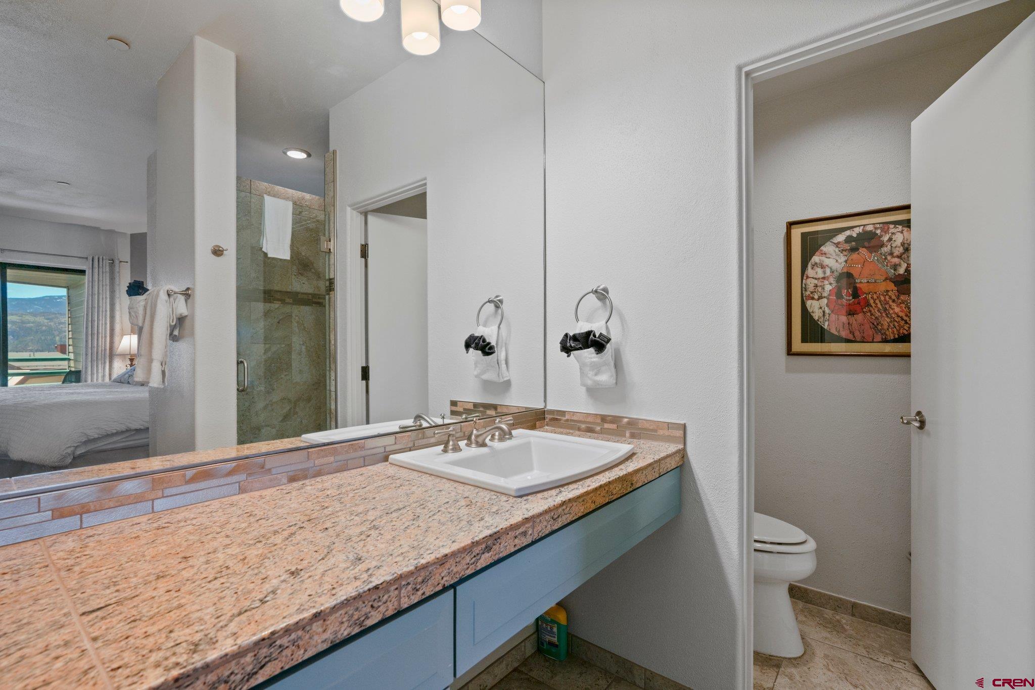 117 Needles Way, Unit 624 Durango, CO 81301 - Photo 6 of 32 a bathroom with a granite countertop sink a toilet and a shower