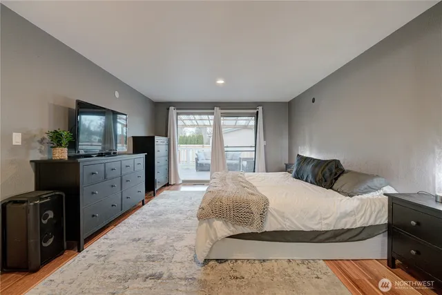 a bedroom with a large bed and dresser with mirror