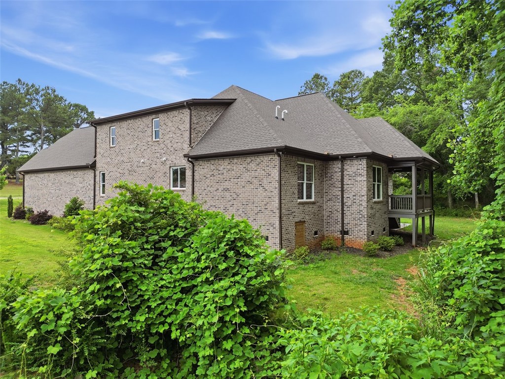 105 Bree Drive Anderson, SC 29621 - Photo 47 of 48 Brick veneer two-story residence nestled among lush greenery, featuring a covered rear porch.