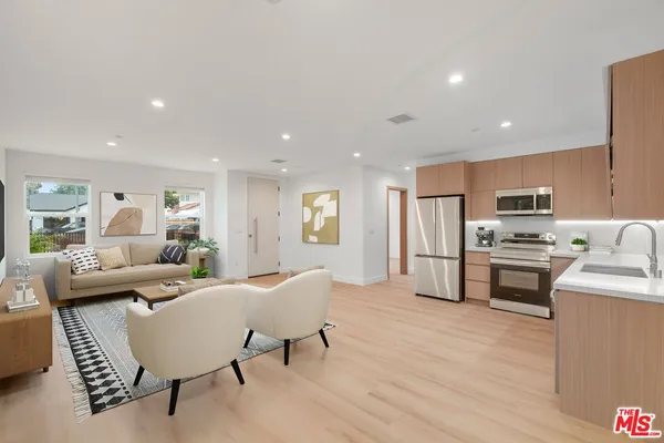 a living room with stainless steel appliances furniture and a table