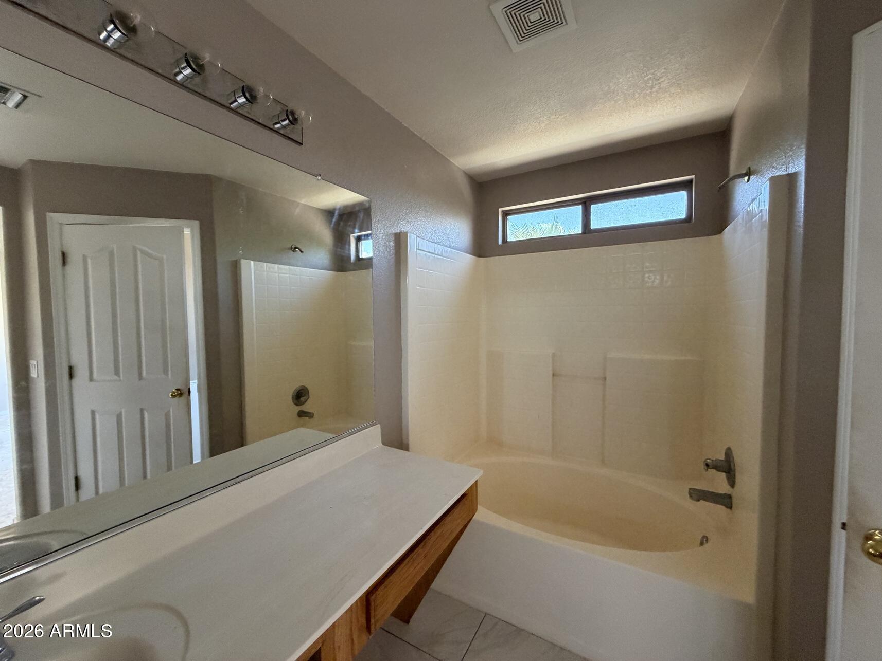 10807 West Monte Vista Road Avondale, AZ 85392 - Photo 30 of 33 a bathroom with a bathtub and shower