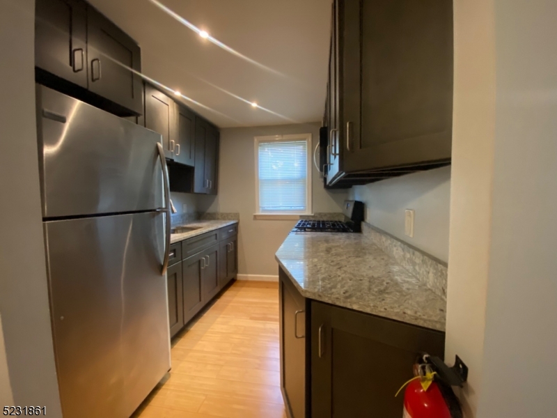 24 East 7th Street, Unit 2 Clifton, NJ 07011 - Photo 2 of 5 a kitchen with stainless steel appliances granite countertop a refrigerator a sink and a stove