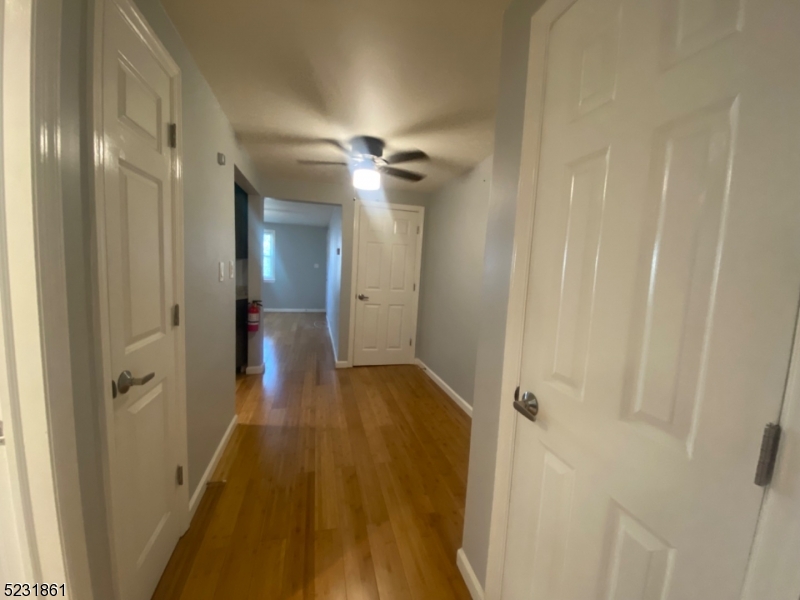 24 East 7th Street, Unit 2 Clifton, NJ 07011 - Photo 3 of 5 a view of a hallway with wooden floor