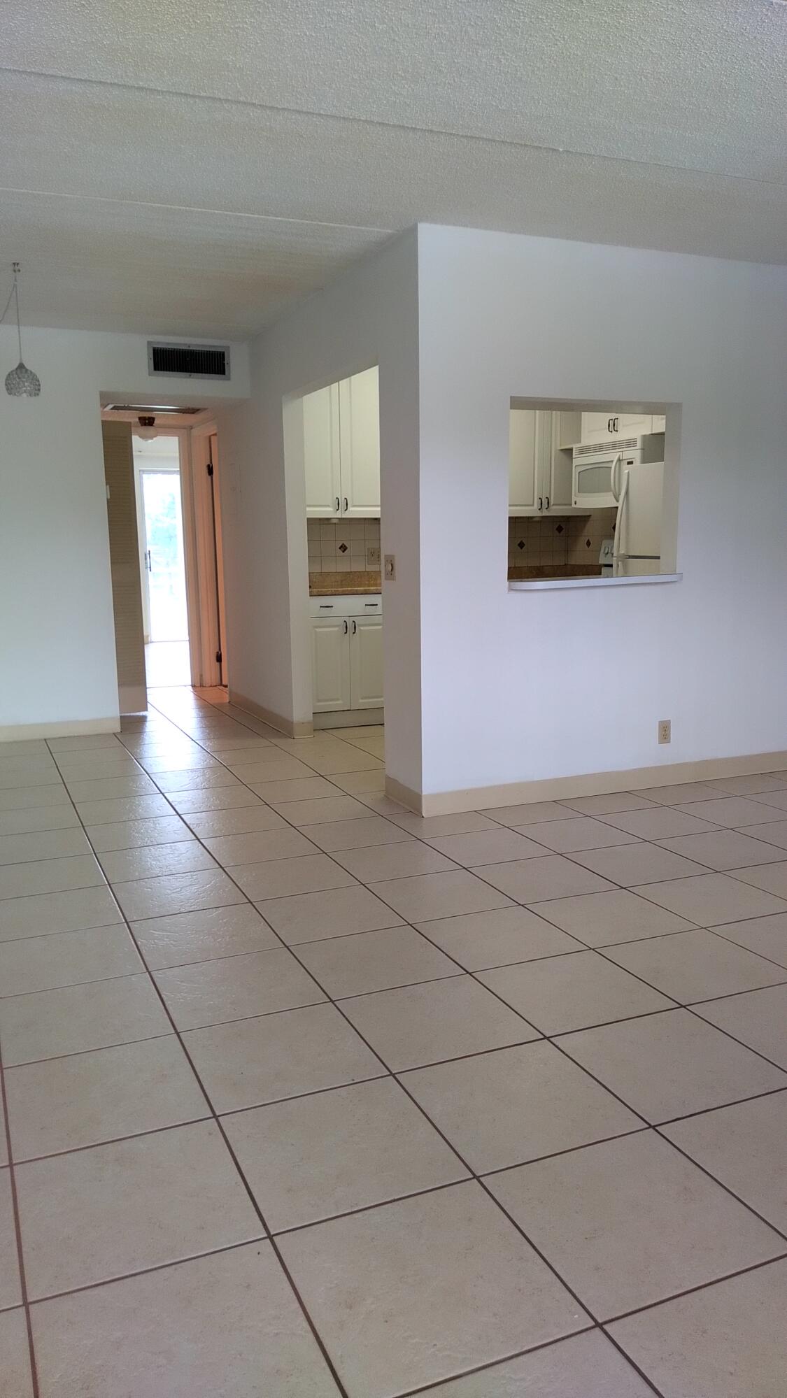 3300 Springdale Boulevard, Unit 208 Palm Springs, FL 33461 - Photo 9 of 21 a view of a livingroom with an empty space and a window