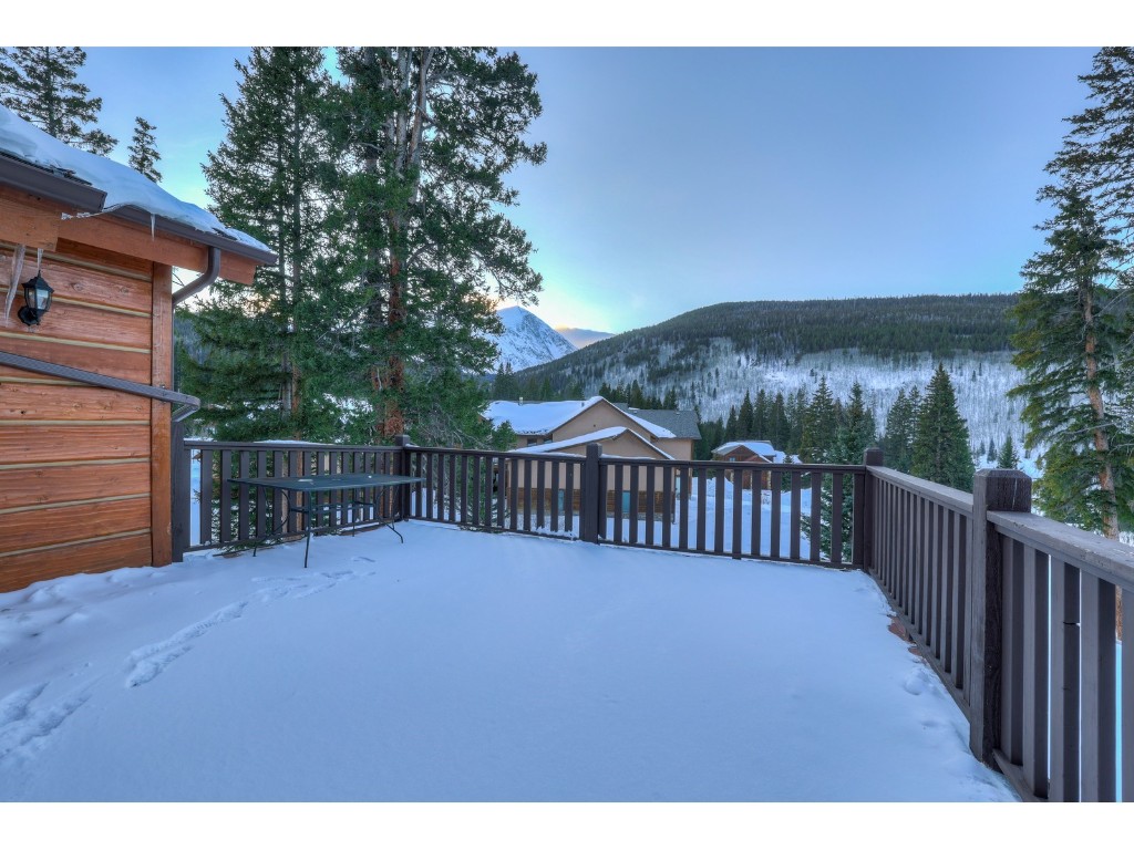 397 Whispering Pines Circle Blue River, CO 80424 - Photo 14 of 35 a view of a deck with a large window and wooden fence