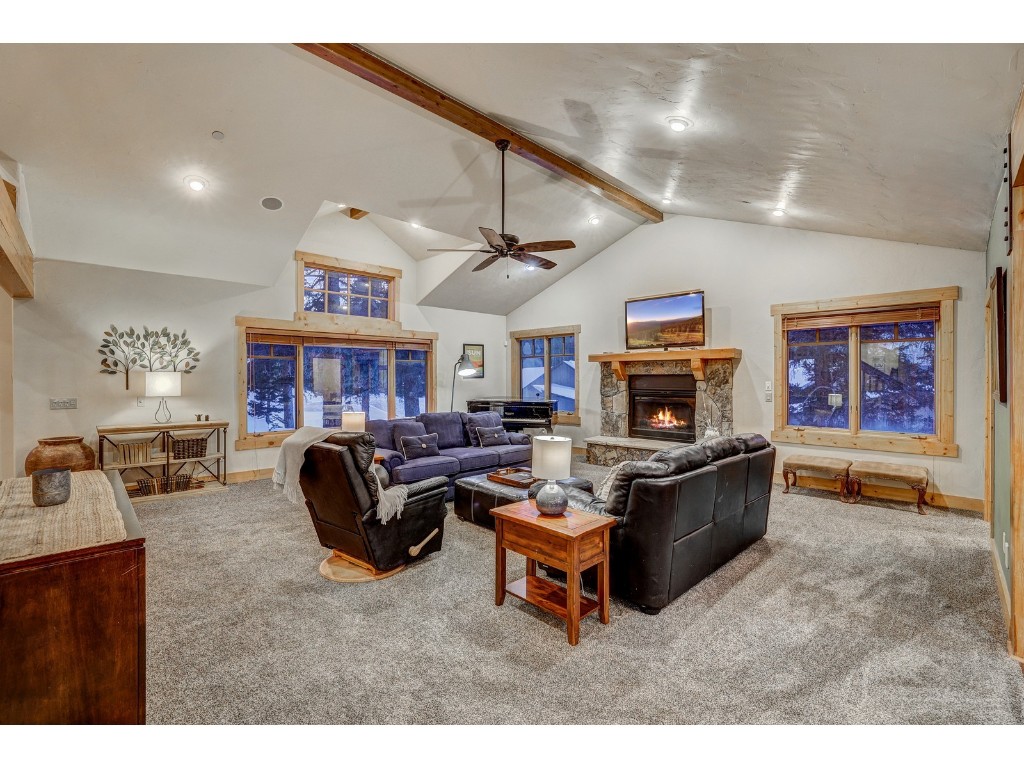 397 Whispering Pines Circle Blue River, CO 80424 - Photo 5 of 35 a living room with furniture a flat screen tv and a fireplace