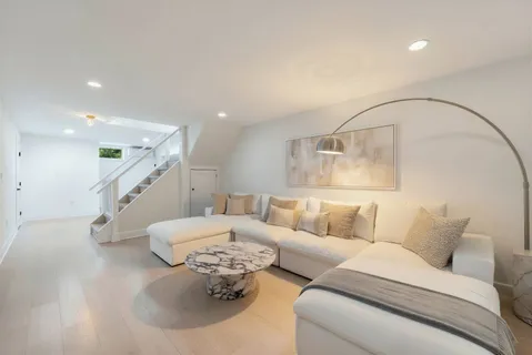 a living room with furniture and stairs